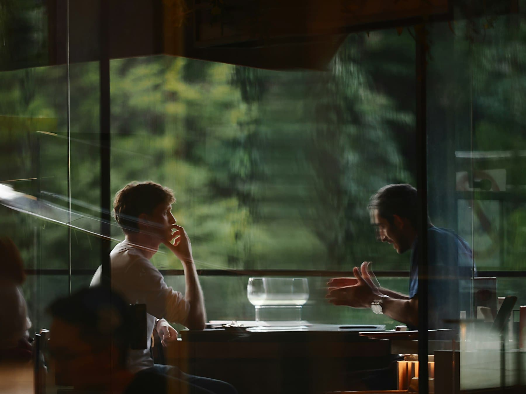 Two people in a focused conversation by a window